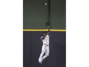 Milwaukee Brewers' Lorenzo Cain makes a catch at the wall on a ball hit by Pittsburgh Pirates' Jordy Mercer during the second inning of a baseball game Friday, Sept. 14, 2018, in Milwaukee.