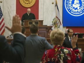 Judge Paul Farrell, left at rostrum, presides over the Senate as senators are sworn in during a pre-trial impeachment conference for four impeached Supreme Court justices in the West Virginia State Senate chambers at the Capitol in Charleston, W,Va., Tuesday, Sept. 11, 2018. Trial dates have not been set.