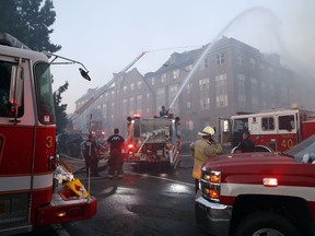 In this Sept. 19, 2018, photo, firefighters pour water on a fire at the Arthur Capper Senior Building, an apartment building that houses senior citizens. Engineers made a startling discovery while inspecting the wreck of a fire-damaged public housing complex. They found a 74-year-old tenant, alive and well, five days after the whole building was supposedly evacuated in the midst of the blaze.