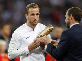 England manager Gareth Southgate hands England's Harry Kane his World Cup Golden Boot before the UEFA Nations League soccer match between England and Spain at Wembley stadium in London, Saturday Sept. 8, 2018.
