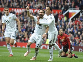 Wolverhampton Wanderers' Joao Moutinho, center left, celebrates after scoring his side's first goal during the English Premier League soccer match between Manchester United and Wolverhampton Wanderers at Old Trafford stadium in Manchester, England, Saturday, Sept. 22, 2018.