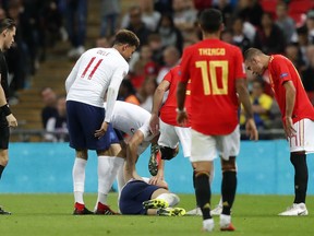 The players look at England's Luke Shaw on the ground after he injured himself during the UEFA Nations League soccer match between England and Spain at Wembley stadium in London, Saturday Sept. 8, 2018.