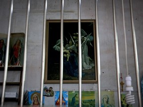 In this Tuesday, March 27, 2018, photo, Catholic religious paintings and figures are displayed behind bars at an underground Catholic church in Jiexi county in south China's Guangdong province.