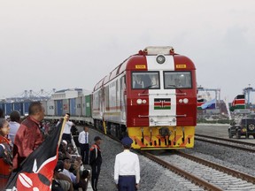 FILE - In this May 30, 2017, file photo, Kenyan President Uhuru Kenyatta, 3rd left, watches during the opening of the SGR cargo train runs on a China-backed railway from the port containers depot in Mombasa Kenya, to Nairobi. A wave of Chinese-financed railways and other trade links in Africa and Asia that have prompted worries about debt and Beijing's ambitions is reducing politically dangerous inequality between regions within countries, a multinational group of researchers said Tuesday, Sept. 11, 2018.