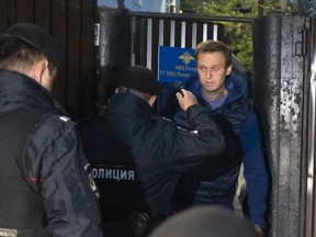 Police officers detain Russian opposition activist Alexei Navalny as he leaves a detention center after a month in jail for an unsanctioned protest rally, in Moscow, Russia, Monday, Sept. 24, 2018.