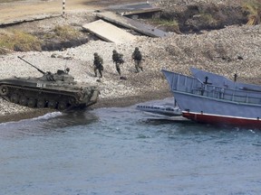 A Russian navy landing vessel unloads an armored vehicle during Russian military maneuvers Vostok 2018 on the training ground "Klerk," about 50 kilometers (31 miles) south of Vladivostok, Russian Far East port, Russia, Saturday, Sept. 15, 2018. The weeklong Vostok 2018 maneuvers are the largest war games Russia ever had.