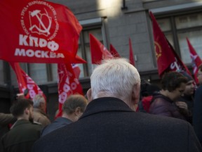 Communist party supporters hold red flags during a protest against the government's plans to raise the retirement age, in front of the Russian State Duma, the Lower House of the Russian Parliament in Moscow, Russia, Wednesday, Sept. 26, 2018. The State Duma is expected to vote on the second reading of the bill that could raise the retirement age for the old-age pension by five years.