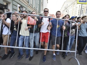 FILE - In this Sunday, Sept. 9, 2018 file photo, young demonstrators carry a police fence during a rally protesting retirement age hikes in Moscow, Russia. Street protests in Russia were once led by 50 and 60 year olds, and young Russians were long considered some of President Vladimir Putin's most loyal supporters, but their children have taken up the lead, taking anti-government protests further, ignoring official bans and unafraid of police brutality.