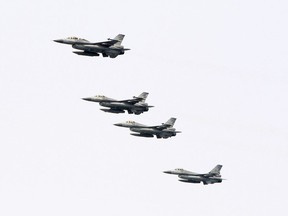 FILE - In this April 13, 2018, file photo, Taiwanese F-16 jet fighters fly in close formation during a navy exercise at Suao naval station in Yilan County, northeastern Taiwan. China demanded Tuesday, Sept. 25, 2018, that the U.S. cancel a $330 million sale of military equipment to Taiwan, warning of "severe damage" to bilateral relations and cooperation if Washington fails to comply. The Trump administration said Monday, Sept. 24, that it had approved the sale of spare parts and related support for Taiwan's F-16 fighters and other military aircraft.