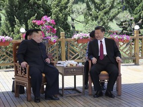 FILE - In this file photo taken between May 7 and 8, 2018, released by China's Xinhua News Agency, Chinese President Xi Jinping, right, speaks to North Korean leader Kim Jong Un in Dalian in northeastern China's Liaoning Province. As North Korea celebrates the 70th anniversary of its founding on Sunday, Sept. 9, 2018, the presence - or absence - of Xi could highlight just how much vitality has been restored to ties between Pyongyang and its most powerful backer after a prolonged chill.