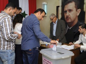 In this photo released by the Syrian official news agency SANA, Syrians cast their votes at a polling station during municipal elections, in Damascus, Syria, Sunday, Sept 16, 2018. Syria is holding its first municipal elections since 2011 amid tensions with the country's self-administered Kurdish region, which is refusing to allow polls. (SANA via AP)