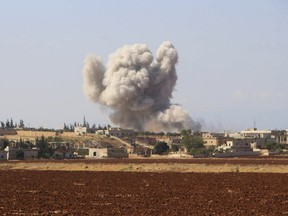 FILE - This file photo released on Monday, Sept 10, 2018 by the Syrian Civil Defense group known as the White Helmets, shows smoke rising from a Syrian government airstrike, in Hobeit village, near Idlib, Syria. As the decisive battle for Idlib looms, a motley crew of tens of thousands of Syrian opposition fighters, including some of the world's most radical, are digging their heels_ looking for ways to salvage what is possible of an armed rebellion that at one point in the seven-year conflict controlled more than half of the country. (Syrian Civil Defense White Helmets via AP, File)