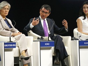 Japanese Foreign Minister Taro Kono, center, gestures talks about Asia's Geopolitcal Outlook in the ongoing World Economic Forum on ASEAN at the National Convention Center Thursday, Sept. 13, 2018 in Hanoi, Vietnam. Listening at left is South Korean Foreign Minister Kang Kyung-wha and Lynn Kuok, International Institute of Strategic Studies, Singapore. The World Economic Forum has attracted hundreds of participants with the theme: ASEAN 4.0: Entrepreneurship and the Fourth Industrial Revolution.