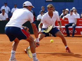 Mike Bryan, left, of the US returns a shot to Ivan Dodig and Mate Pavic during the Davis Cup semifinal double match between Croatia and the United States in Zadar, Croatia, Saturday, Sept. 15, 2018.