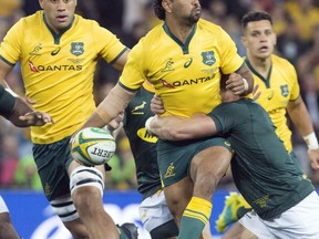 Australia's Kurtley Beale, center, is tackled during their rugby union test match against South Africa in Brisbane, Australia, Saturday, Sept. 8, 2018.