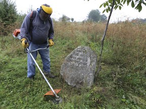 In this photo taken on Aug. 29, 2018, Steven Reece, an ordained Southern Baptist minister who lives near Atlanta cleans an old Jewish cemetery in Rohatyn, the site of a Jewish Heritage project, close to Lviv, Ukraine, Aug. 29, 2018. For years now, Reece, an ordained Southern Baptist minister from Texas, has been cleaning Jewish cemeteries and erecting memorial plaques at mass grave sites in Poland, and recently Ukraine.