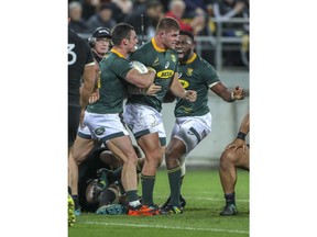 South Africa's Malcolm Marx, center, is congratulated on his try by teammates Jesse Kriel and Siya Kolisi, right, during a rugby championship test match between South Africa and New Zealand in Wellington, New Zealand, Saturday, Sept. 15, 2018.