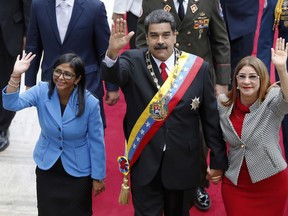 FILE - In this May 24, 2018 file photo, Venezuela's President Nicolas Maduro, then Constituent National Assembly President Delcy Rodriguez, left, and first lady Cilia Flores, wave as they arrive to the National Assembly, in Caracas, Venezuela. The Trump administration slapped financial sanctions Tuesday, Sept. 25, 2018, on four members of Maduro's inner circle, including his wife, and Rodriguez who is now the nation's vice president, on allegations of corruption.