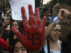 FIE - In this Oct. 22, 2014 file photo, peopole protest the disappearance of 43 students in Mexico City. Mexican President Enrique Pena Nieto has again on Wednesday, Aug. 29, 2018, defended the widely criticized original investigation of the disappearance of the 43 students, but concedes that his administration has failed to bring the country peace.