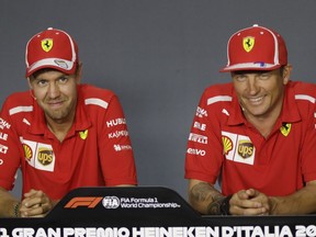 FILE - In this  Aug. 30, 2018 file photo, Ferrari driver Sebastian Vettel of Germany, left, is flanked by his teammate Kimi Raikkonen of Finland during a news conference at the Monza racetrack, in Monza, Italy. Kimi Raikkonen is leaving Ferrari for Sauber and will be replaced by rookie Charles Leclerc, that will team up with Sebastian Vettel.