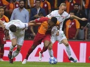 Galatasaray's forward Garry Rodrigues, centre, fights for the ball with Lokomotiv Moscow's midfielder Grzegorz Krychowiak left and midfielder Vladislav Ignatyev right, during the Champions League Group D soccer match between Galatasaray and Lokomotiv Moscow in Istanbul, Tuesday, Sept. 18, 2018. (AP Photo)
