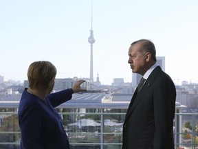 German Chancellor Angela Merkel, left, talks to Turkish President Recep Tayyip Erdogan, right, prior to their breakfast meeting at the chancellery in Berlin, Germany, Saturday, Sept. 29, 2018. Erdogan is on a three-day official state visit to Germany. (Presidential Press Service via AP, Pool)