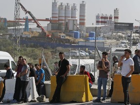 Plain clothed police officers and security gather at the entrance of Istanbul new airport construction site in Istanbul, Saturday, Sept.15, 2018.  A trade union leader says police in Turkey have rounded up hundreds of construction workers at Istanbul's new airport after they staged a protest denouncing poor working conditions.