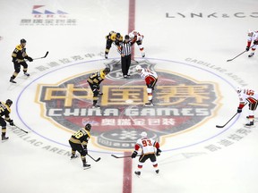 Jakob Forsbacka Karlsson (23) of the Boston Bruins, center left, and Mark Jankowski (77) of the Calgary Flames face off at the start of their 2018 NHL China Games hockey game in Beijing, China, Wednesday, Sept. 19, 2018.