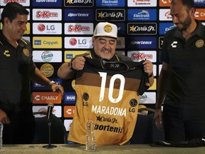 Former soccer great Diego Maradona shows his team jersey during a press conference where he was presented as the new manager of the Dorados of Sinaloa, in Culiacan, Mexico, Monday, Sept. 10, 2018. Maradona, whose public battles with cocaine made him soccer's poster child for the perils of substance abuse, is setting up camp in Mexico's drug cartel heartland as the new coach of a second-tier team.