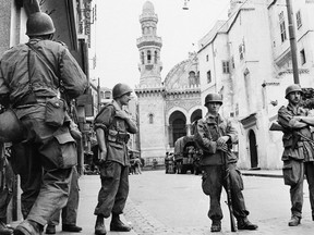 FILE - In this May 27, 1956 file photo, French troops seal off Algiers' notorious casbah, 400-year-old teeming Arab quarter. French President Emmanuel Macron has formally recognized that the French state was responsible for the death of a dissident mathematician in Algeria in 1957, admitting for the first time the French military's "system" of torture during Algeria's independence war. (AP Photo)