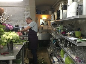 In this Thursday, Sept. 13, 2018 photo, a florist prepares flowers in the flower atelier of the Elysee presidential palace in Paris. The French president's wine cellar contains 14,000 bottles so precious that only a lucky few can enter it. Flower bouquets are displayed only for a couple of hours so they always look fresh. And the presidential chefs cook in 150-year-old pans. These and other behind-the-scenes quirks of the Elysee Palace are now getting a rare airing.