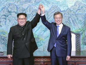 FILE - In this April 27, 2018 file photo, North Korean leader Kim Jong Un, left, and South Korean President Moon Jae-in raise their hands after signing a joint statement at the border village of Panmunjom in the Demilitarized Zone, South Korea. South Korea's liberal president faces growing skepticism at home about his engagement policy ahead of his third summit with North Korean leader Kim Jong Un. A survey showed nearly half of South Koreans think next week's summit won't find a breakthrough to resolve a troubled nuclear diplomacy. It comes as Moon's approval rating is declining amid economic frustrations. (Korea Summit Press Pool via AP, File)