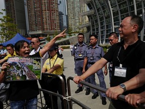 A woman shouts slogans during a protest outside the Western Kowloon Station against the opening ceremony of the Hong Kong Express Rail Link in Hong Kong, Saturday, Sept. 22, 2018. Hong Kong has opened a new high-speed rail link to inland China that will vastly decrease travel times but which also raises concerns about Beijing's creeping influence over the semi-autonomous Chinese region.