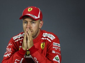 Ferrari driver Sebastian Vettel of Germany looks on during a press conference following the qualifying session at the Marina Bay City Circuit ahead of the Singapore Formula One Grand Prix in Singapore, Saturday, Sept. 15, 2018.