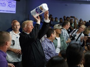 President Donald Trump tosses paper towels into a crowd at Calvary Chapel in Guaynabo, Puerto Rico, on Oct. 3, 2017.
