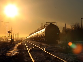 The sun sets on a roll of train tanker cars sitting idle along some railway tracks near a refinery in Fort Saskatchwan, Alta.