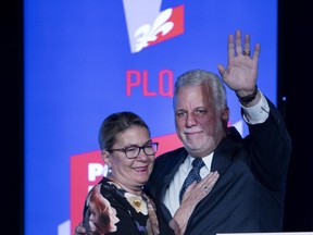 Liberal Leader Philippe Couillard waves to supporters in St-Félicien, alongside his wife, Suzanne Pilote, after conceding the Quebec election on Monday night.