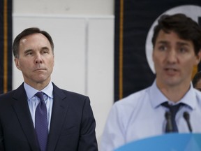 Bill Morneau, Canada's finance minister, listens as Canadian Prime Minister Justin Trudeau, speaks during an event in Toronto, Ontario, Canada, on Tuesday, Oct. 23, 2018.