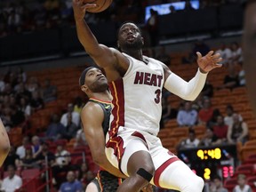 Miami Heat's Dwyane Wade (3) drives past Atlanta Hawks' Vince Carter during the first half of a preseason NBA basketball game, Friday, Oct. 12, 2018, in Miami.