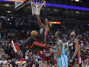 Miami Heat's Hassan Whiteside (21) dunks in front of Charlotte Hornets guard Dwayne Bacon as Heat forward Derrick Jones Jr. (5) reacts during the first half of an NBA basketball game, Saturday, Oct. 20, 2018, in Miami.