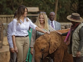 U.S. first lady Melania Trump pets a baby elephant, accompanied by CEO Angela Sheldrick, center, and Kenya's first lady Margaret Kenyatta, right, at the David Sheldrick Wildlife Trust elephant orphanage in Nairobi, Kenya Friday, Oct. 5, 2018. Trump took part in a baby elephant feeding on Friday as she visited a national park in Kenya to highlight conservation efforts. Kenya is the third stop on her Africa tour, which began Tuesday in Ghana and continued in Malawi on Thursday.