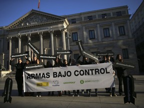 Activists holding banners in the shape of missiles and a banner reading in Spanish "Arms under control" protest against the sale of weapons to Saudi Arabia in front of the Spanish Parliament in Madrid, Wednesday, Oct. 24, 2018. Spain's prime minister says his government will fulfill past arms sales contracts with Saudi Arabia despite his "dismay" over the "terrible murder" of journalist Jamal Khashoggi.