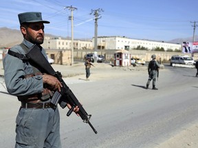 In this Wednesday Oct. 17, 2018, photo, Afghan Police stand guard at a checkpoint ahead of parliamentary elections, in Kabul, Afghanistan. The elections are being held Saturday despite deep security concerns and ongoing fighting in as many as 20 out of the country's 34 provinces. More than 50,000 members of the Afghan security forces will be deployed to secure polling stations.