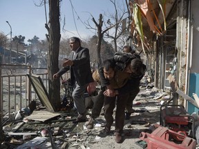 Afghan volunteers carry a body at the scene of a car bomb exploded in front of the old Ministry of Interior building in Kabul on January 27, 2018. An ambulance packed with explosives blew up in a crowded area of Kabul on January 27, killing at least 17 people and wounding 110 others, officials said, in an attack claimed by the Taliban.