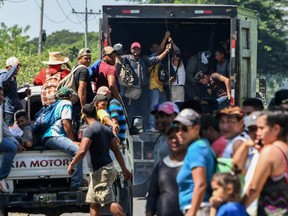 Hondurans drive on vans and trucks towards U.S. from San Pedro Sula, 180 kilometres north of Tegucigalpa, on October 13, 2018.