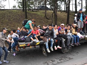 Honduran migrants aboard vehicles head in a caravan to the United States, in Guatemala City, on October 18, 2018.