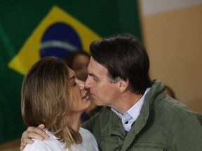 Jair Bolsonaro, far-right lawmaker and presidential candidate of the Social Liberal Party (PSL), and his wife Michelle kiss before casting their votes, in Rio de Janeiro, Brazil October 28, 2018