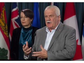 PIPSC President Debi Daviau looks on as PSAC President Chris Aylward speaks about the Phoenix pay system during a news conference about pay equity in Ottawa, Wednesday October 31, 2018.