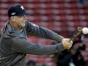 Houston Astros manager AJ Hinch hits during batting practice before Game 2 of a baseball American League Championship Series against the Boston Red Sox on Sunday, Oct. 14, 2018, in Boston.