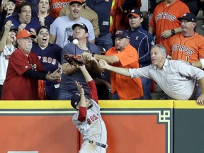 Fans interfere with Boston Red Sox right fielder Mookie Betts trying to catch a ball hit by Houston Astros' Jose Altuve during the first inning in Game 4 of a baseball American League Championship Series on Wednesday, Oct. 17, 2018, in Houston. Altuve was called out.